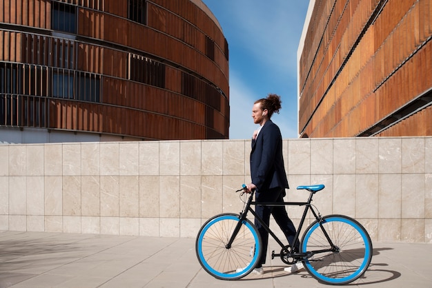 Foto gratuita joven en bicicleta yendo al trabajo tiro completo