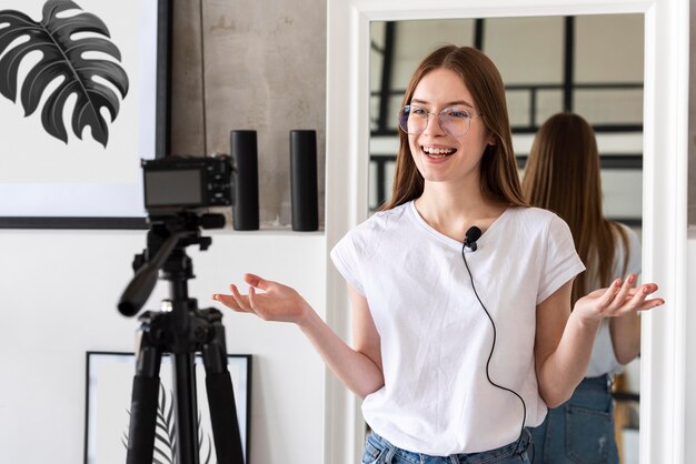 Joven blogger grabando con cámara profesional y micrófono