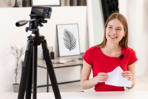 Foto gratuita joven blogger sonriendo y sosteniendo un papel