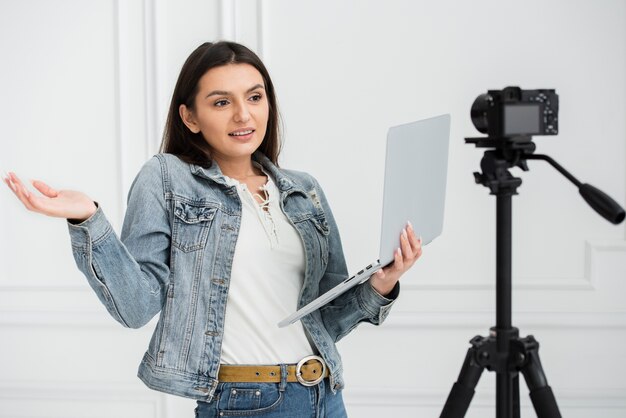 Joven blogger sosteniendo una laptop