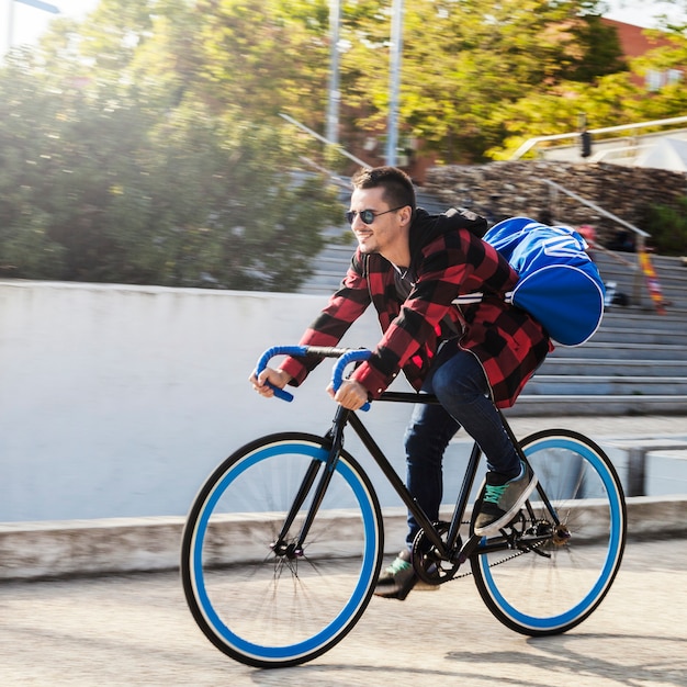 Foto gratuita joven con bolsa de bicicleta de montar