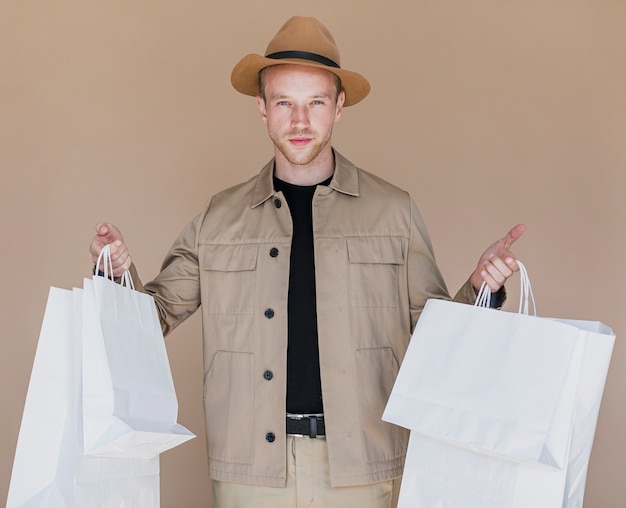 Foto gratuita joven con bolsas de compras en ambas manos