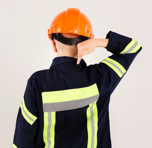 Joven bombero apuntando al uniforme