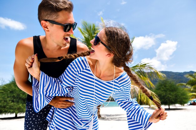 Joven bonita pareja de jóvenes viajeros divirtiéndose en románticas vacaciones tropicales, vacaciones en la isla paradisíaca, relax de verano. Mirándose y sonriendo.