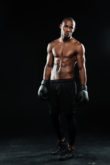 Joven boxeador afroamericano en guantes, de pie