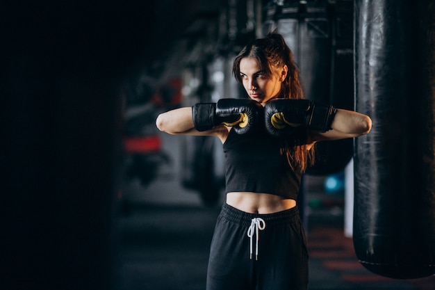 Foto gratuita joven boxeador entrenando en el gimnasio