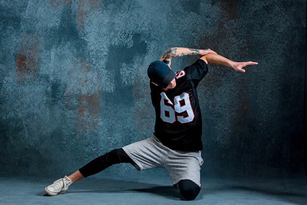 Joven break dance sobre fondo de pared.