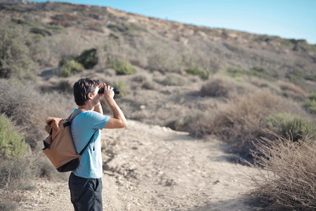 joven buscando objetivo con binoculares