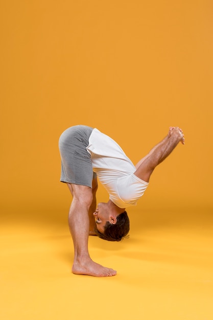 Foto gratuita joven en cabeza a los dedos yoga pose