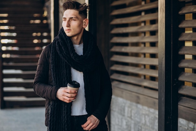 Joven con café caminando en la calle