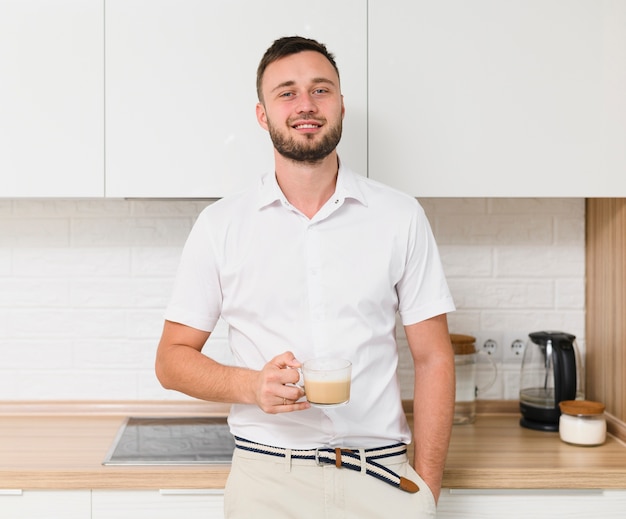 Joven con café sonriendo a la cámara