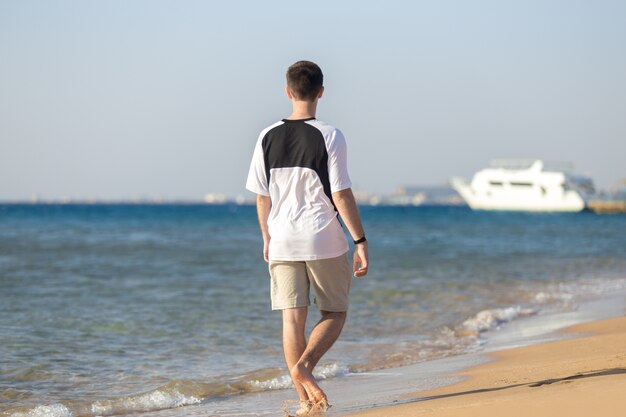 Joven caminando en la costa