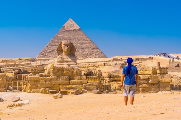 Foto gratuita joven caminando hacia la gran esfinge de giza un