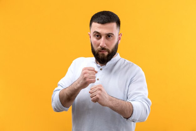 Joven de camisa blanca con barba en la pose de lucha