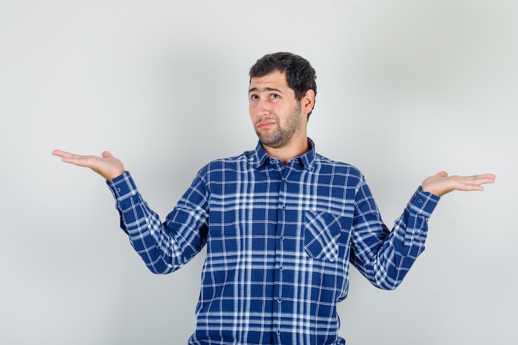 Foto gratuito joven en camisa de cuadros mostrando gesto de impotencia