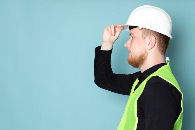 Foto gratuita joven de camisa negra y chaleco de construcción verde