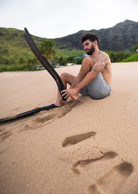 Foto gratuita joven sin camisa en la playa con equipo de buceo