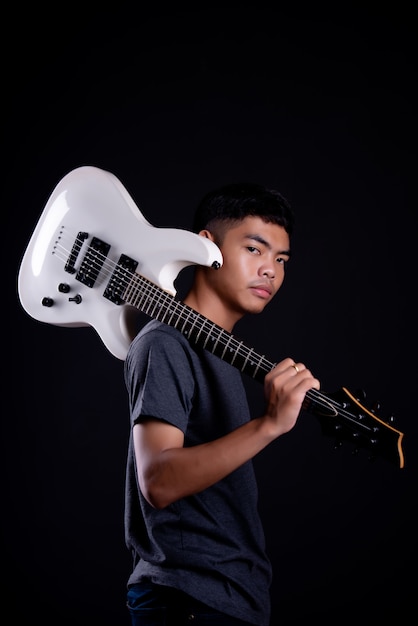 Foto gratuita joven en camiseta oscura con guitarra eléctrica