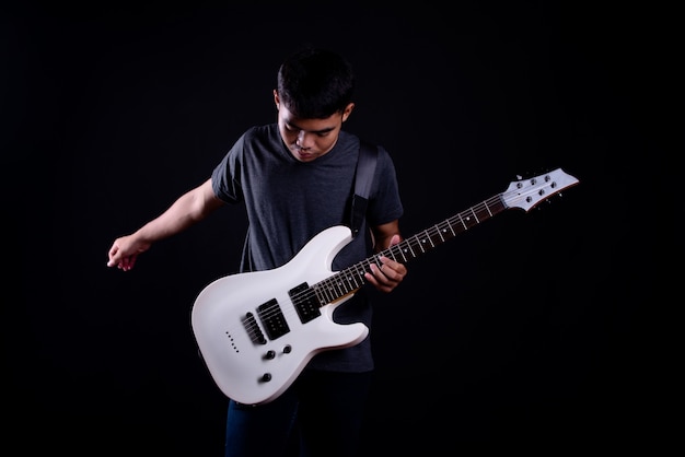 joven en camiseta oscura con guitarra eléctrica