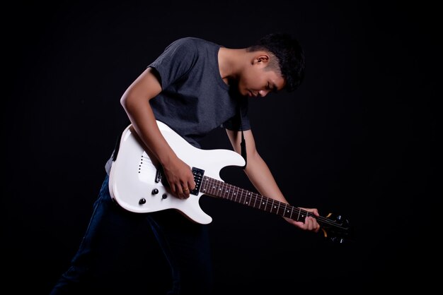 joven en camiseta oscura con guitarra eléctrica