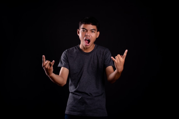 joven en camiseta oscura haciendo un gesto rockero