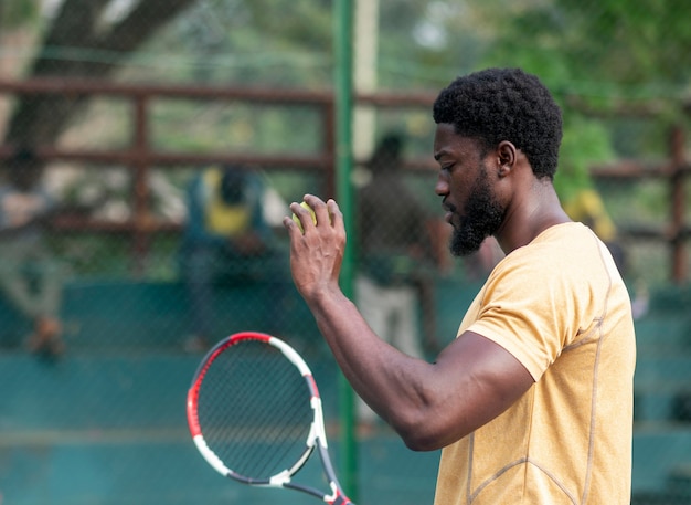 Foto gratuita joven, en, cancha de tenis, juego