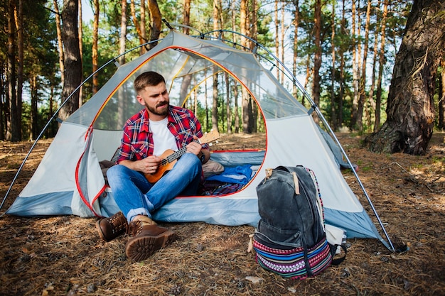 Foto gratuita joven en carpa jugando quitar