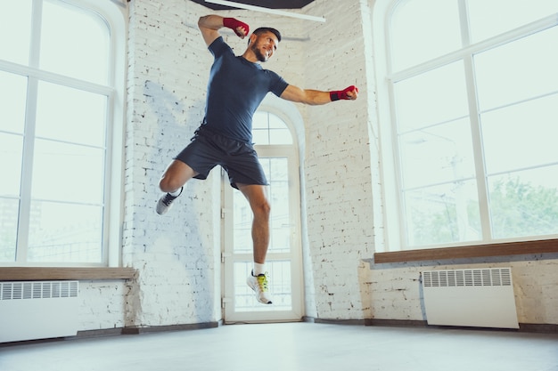 Joven caucásica formación en casa durante la grabación de cursos en línea, ejercicios doinc de fitness, aeróbico. Mantenerse aislante deportivo suring.