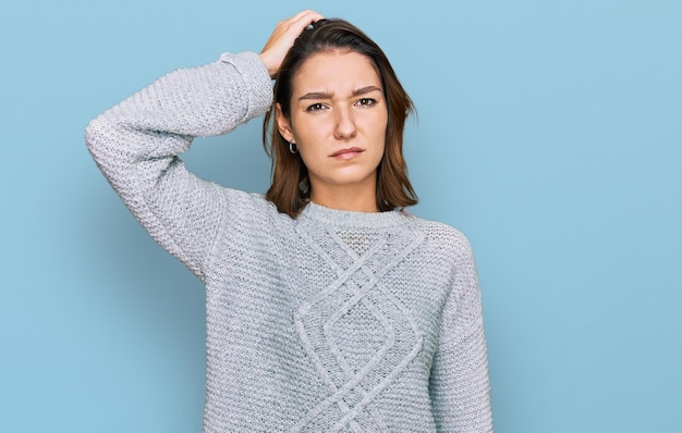 Una joven caucásica con ropa informal confunde y se pregunta sobre la pregunta incierta con dudas pensando con la mano en la cabeza concepto pensativo