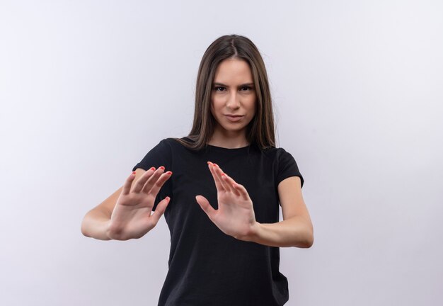 Joven caucásica vestida con camiseta negra mostrando gesto de parada en pared blanca aislada