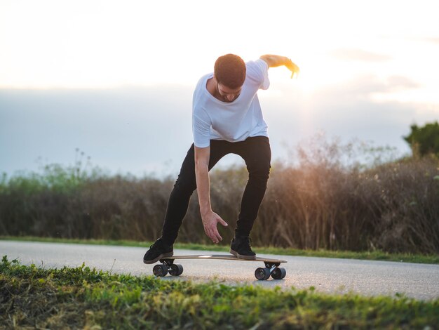 Joven caucásico haciendo trucos con una patineta en la calle