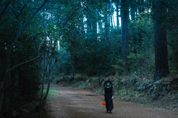 Joven con cesta en el bosque espeluznante