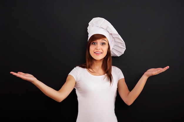 Joven chef de cocina sonriente mostrando signo de saludo