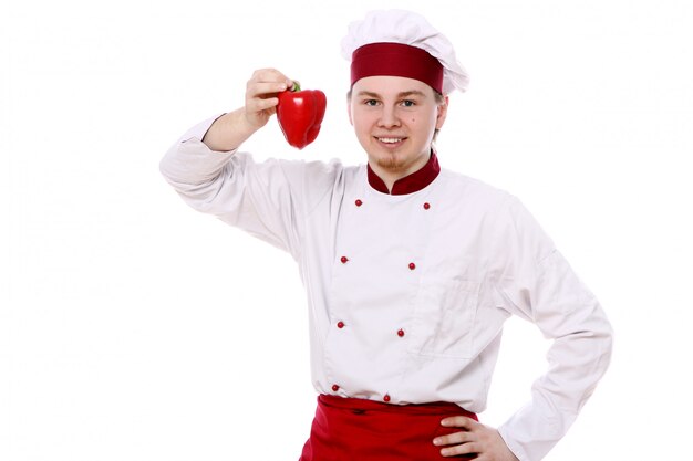 Joven chef con pimentón rojo