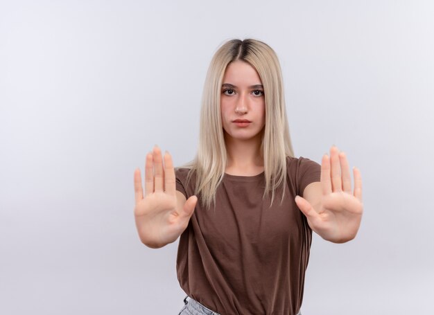 Joven chica rubia estirando las manos gesticulando parada en pared blanca aislada con espacio de copia