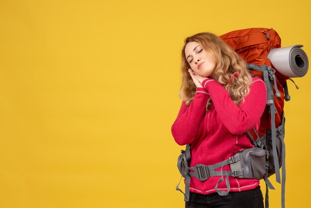 Joven chica viajera soñolienta recogiendo su equipaje