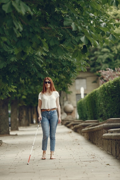 Foto gratuita joven ciego con bastón largo caminando en una ciudad