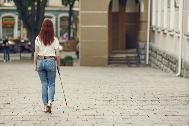 Foto gratuita joven ciego con bastón largo caminando en una ciudad