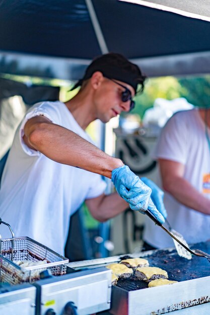 Un joven cocina al aire libre