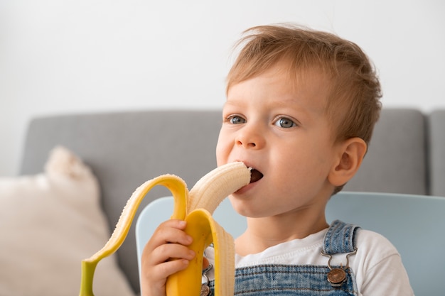 Foto gratuita joven comiendo un plátano en casa