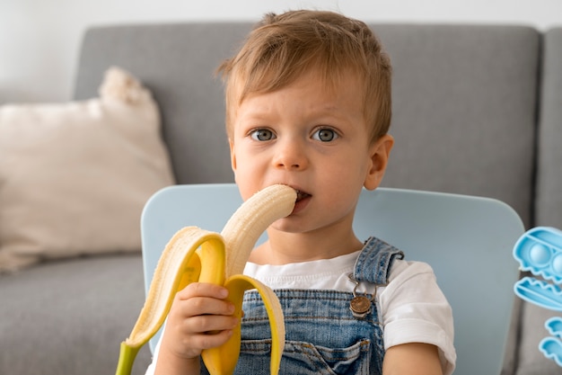 Foto gratuita joven comiendo un plátano en casa