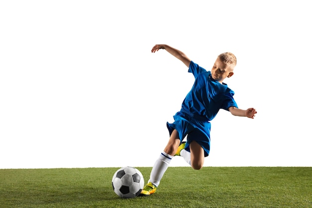 Foto gratuita joven como un jugador de fútbol o fútbol en ropa deportiva haciendo una finta o una patada con el balón para un gol sobre fondo blanco.