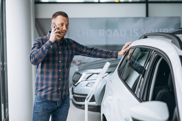 Foto gratuita joven comprando un automóvil en una sala de exposición de automóviles