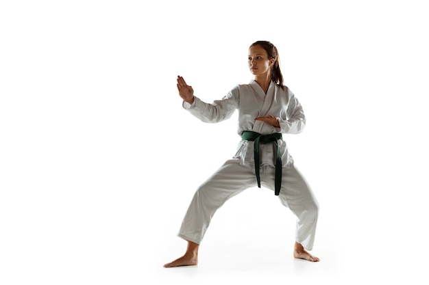 Joven confiado en kimono practicando combate cuerpo a cuerpo