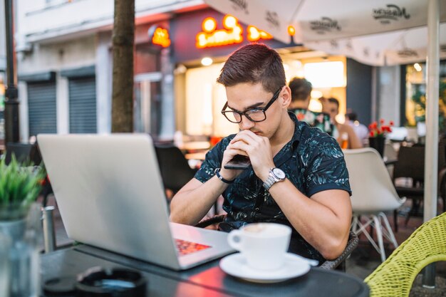 Joven contemplado sentado en un café