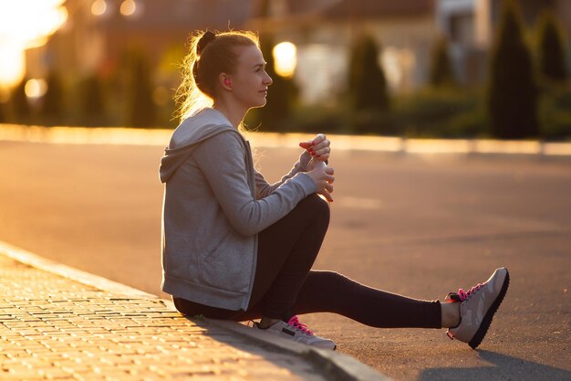 Joven corredora, atleta durante el jogging en las calles de la ciudad bajo el sol