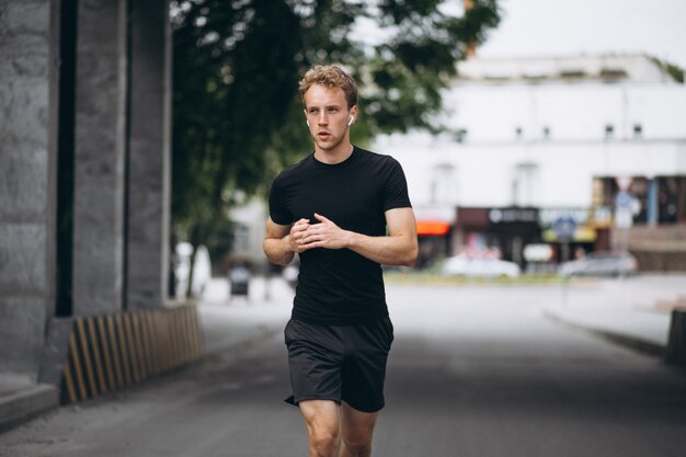 Joven corriendo en la ciudad por la mañana