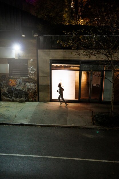 Joven corriendo de noche en las calles de la ciudad