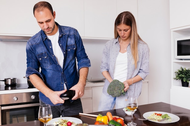 Joven cortando las verduras en la cocina