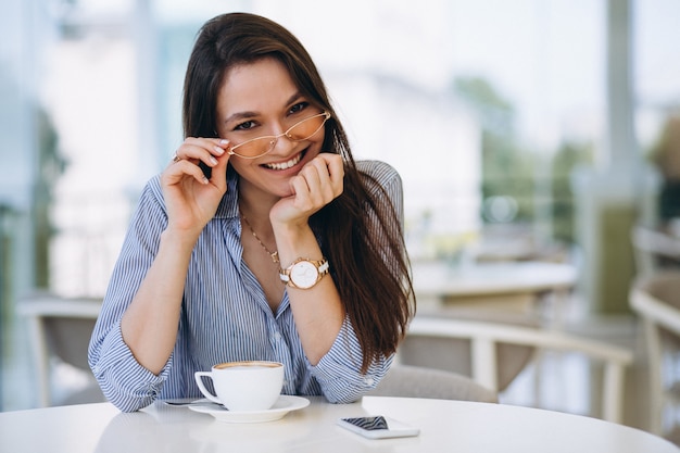 Joven dama bebiendo té en un café